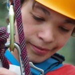 Porträt eines Jungen mit Kletterausrüstung. Inklusive Kletterreise des Indiwi Berlins.